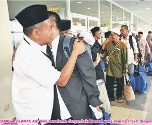  ??  ?? SEMOGA SELAMAT: Aziz (kiri) bersalaman dengan bakal jemaah yang akan berangkat dengan penerbanga­n ke Kuching.