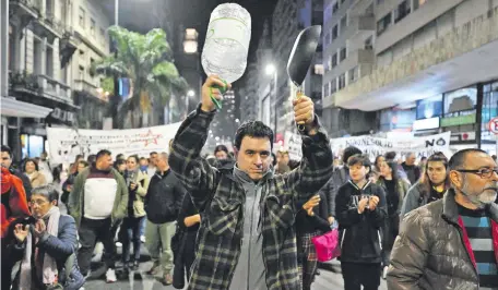  ?? ?? Activistas y sindicalis­tas golpearon botellas y bidones de agua vacíos durante una protesta en Montevideo. (AFP)