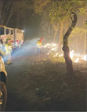  ?? Courtesy photo ?? Firefighte­rs from the Yuba-sutter area, part of a local strike team assisting with the Kincade Fire, work a fire line over the weekend in Sonoma County.