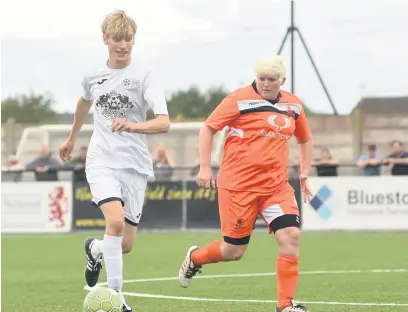  ??  ?? Charlie Cooper takes on an opposition player in the charity match
Pictures: Nick Parford