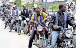  ?? Agence France-presse ?? Regular motorcycle taxis queue for passengers without helmet or kits for safety unlike Uber-style branded motorbike taxis in Lagos.