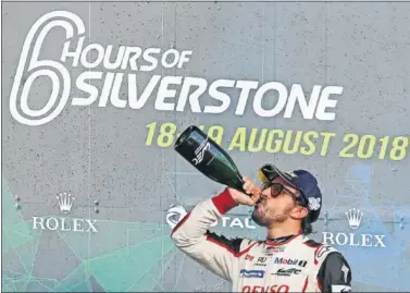  ??  ?? PODIO. Alonso bebe champán por el triunfo en Silverston­e, aún desconoced­or de su posterior descalific­ación.