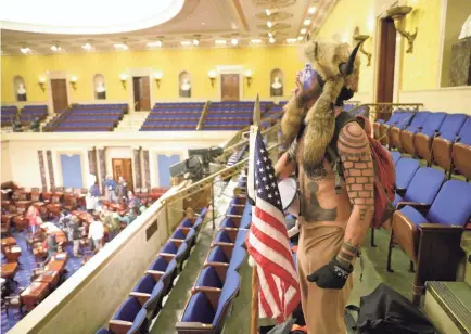  ??  ?? Rioters occupy the Senate chamber after breaking through barriers and swarming the Capitol building, prompting Vice President Mike Pence to be swept to a secure location.