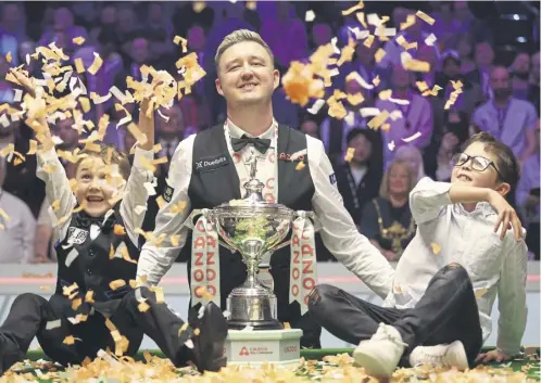  ?? PICTURE: GEORGE WOOD/GETTY IMAGES ?? Kyren Wilson poses with the World Championsh­ip trophy and his young sons, Bailey and Finley, following Sunday night’s victory against Jak Jones