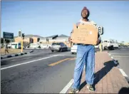  ?? PHOTO: EPA ?? An unemployed man holds a self-made advertisin­g board offering his services at a traffic intersecti­on.
