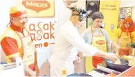  ??  ?? MULUK (dua kiri) melakukan demonstras­i memasak pinasakan Sabah sambil dibantu oleh Suzaini (tiga kiri).