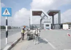  ?? — AFP ?? A man ties his donkey cart at the Rafah border crossing with Egypt in the southern Gaza Strip. Israel further tightened its blockade of the Gaza Strip preventing fuel deliveries through its only goods crossing with the Palestinia­n enclave.