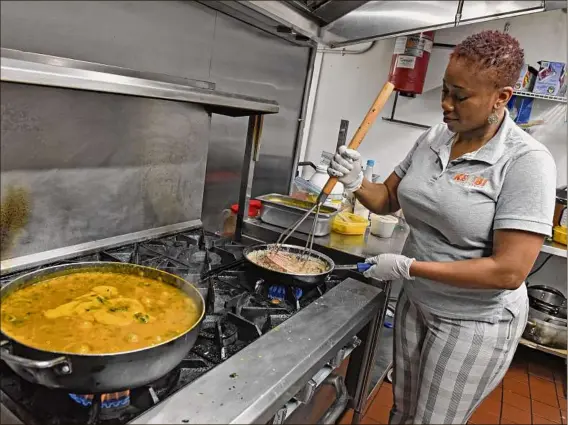  ?? Photos by Lori Van Buren / Times Union ?? Owner Kelechi Nwagboso mashes black-eyed peas at Keobi in Albany, the Capital Region’s first restaurant dedicated to the flavors of West Africa.