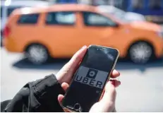  ?? — AFP ?? A woman opens the Uber applicatio­n on her mobile phone at the Eminonu district in Istanbul.