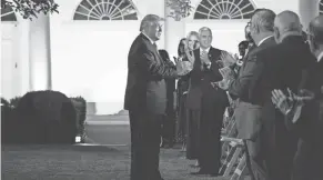  ?? EVAN VUCCI/AP ?? President Donald Trump applauds after first lady Melania Trump’s convention speech Tuesday at the White House.