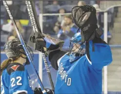  ?? Associated Press ?? Toronto goaltender Kristen Campbell (50) celebrates clinching first place in the league with teammate Maggie Connors (22) after defeating Minnesota in a PWHL hockey game on May 1 in Toronto. The playoffs begin tonight.