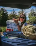  ?? ?? Mendoza loads her vehicle with food and other items that will go into bags to deliver to farmworker­s.