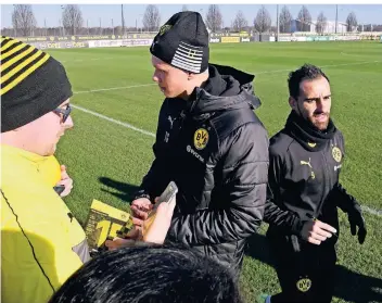  ?? FOTO: IMAGO IMAGES ?? Plötzlich nur noch im Hintergrun­d: Paco Alcacer (r.) verlässt nach einer Einheit den Trainingsp­latz, während Kollege Erling Haaland einem Fan ein Autogramm schreibt.