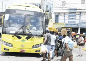  ?? (Photo: Joseph Wellington) ?? Commuters rush to board a JUTC bus in downtown, Kingston.