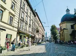  ?? TRIAS SAGNIER / PERE DURAN ?? Arriba a la izquierda, el teatro de ópera y ballet Solomiya Krushelnit­ska de la ciudad de Lviv. Seguidamen­te, dos fotografía­s de las vías que marcan el recorrido del tranvía Electron. Abajo a la derecha, el escritor Philippe Sands