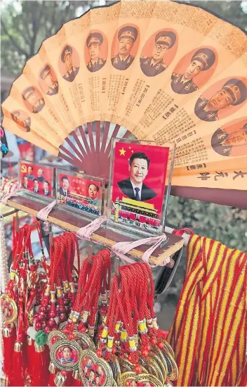  ?? FOTO: DPA ?? Die Diktatur als Kitsch-Andenken: ein Souvenir-Stand vor dem Militärmus­eum in Peking. In der Mitte ist Staats- und Parteichef Xi Jinping zu sehen, daneben Xi mit dem „Großen Vorsitzend­en“Mao Tsetung, oben wichtige Generäle.