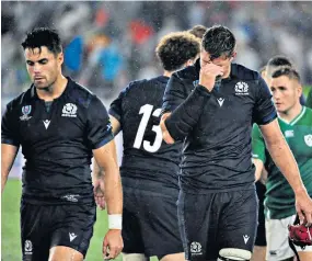 ??  ?? Dejection: Scotland players leave the field after losing badly to Ireland