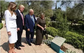  ??  ?? PRESIDENT REUVEN RIVLIN, US President Donald Trump and their wives read the plaque of a tree planted in honor of Trump’s visit at the President’s Residence in Jerusalem yesterday.