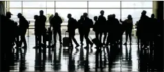  ?? RICK BOWMER — THE ASSOCIATED PRESS FILE ?? Travelers walk through the Salt Lake City Internatio­nal Airport in March. Of the 2million people clogging airport security lines and gate areas again each day, one crowd is still largely missing: business travelers.