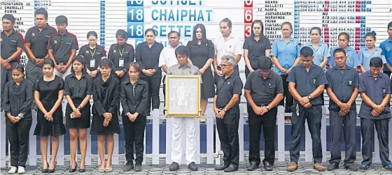  ??  ?? Golfers and officials take part in a solemn ceremony to mark one year since the death of King Bhumibol Adulyadej before yesterday’s second round.