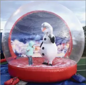  ?? JESI YOST — FOR DIGITAL FIRST MEDIA ?? Hailey Schollenbe­rger, 3, of Oley, jumps in a giant snow globe with Olaf from Disney “Frozen” during Amity’s Winterfest.