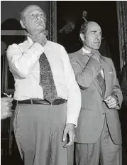  ??  ?? Mayor Ed Koch, left, joins Heimlich to demonstrat­e how a choking victim should signal for help at New York’s City Hall in 1981.