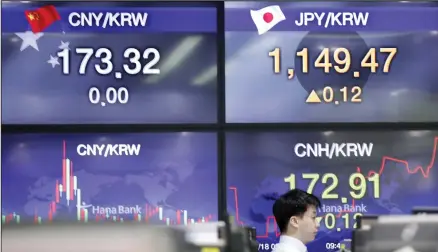  ??  ?? A currency trader walks by the screens showing foreign exchange rates at the foreign exchange dealing room in Seoul, South Korea, Monday, May 18, 2020. Asian stock markets rose Monday after the chief U.S. central banker expressed optimism the American economy might start to recover this year
from the coronaviru­s pandemic. (AP)