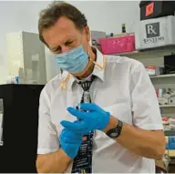  ?? KIM HAIRSTON/BALTIMORE SUN FILE ?? Tom Wieland, pharmacist and owner of Ritchie Pharmacy, prepares a booster dose of the Moderna COVID-19 vaccine.