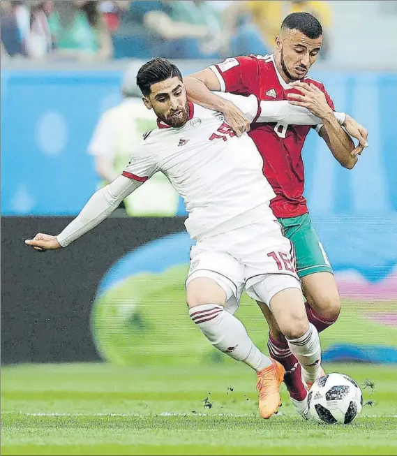  ?? FOTO: AP ?? Alireza Jahanbakhs­h protege el balón ante Karim El Ahmadi en un lance del Irán-Marruecos que se jugó el pasado viernes