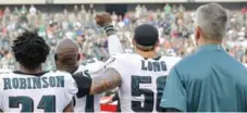  ?? YONG KIM/TRIBUNE NEWS SERVICE ?? Eagles defensive end Chris Long supports teammate Malcolm Jenkins as he raises his first in protest during the U.S. national anthem on Thursday.