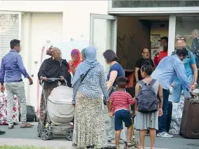  ??  ?? L’attesa Alcune famiglie di profughi ieri davanti alla palazzina dell’ex Moi di Torino