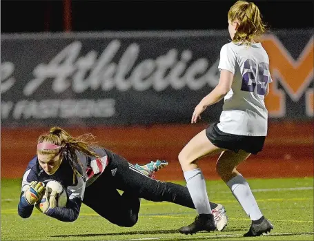  ?? SARAH GORDON/THE DAY ?? Montville goalie Lauren Ross comes out of her net and beats Ellington’s Megan Johndrow (25) to the ball during Wednesday night’s Class M state girls’ soccer tournament game at Montville. Ellington won 1-0. Visit www.theday.com to view a photo gallery.
