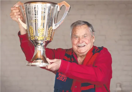  ?? ?? Dare to dream Dees - Melbourne Football Club gives legend Ron Barassi the 2021 AFL Trophy to hold at his home. Picture: David Caird