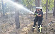  ?? FOTO: IMAGO/OLAF WAGNER ?? Ehrenamtli­ches Engagement: Zwei Frauen von der Freiwillig­en Feuerwehr löschen nach einem Waldbrand Glutnester.