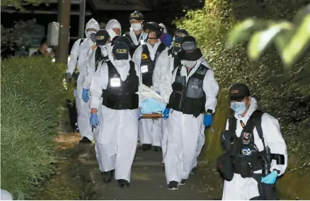  ?? Yonhap ?? Policemen carry the body of the late Seoul Mayor Park Won-soon who was found dead in northern Seoul, early Friday.