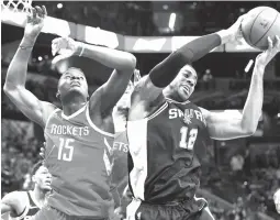  ?? Darren Abate/The Associated Press ?? ■ San Antonio Spurs’ LaMarcus Aldridge (12) grabs the rebound away from Houston Rockets’ Clint Capela during the first half of an NBA game Sunday in San Antonio.