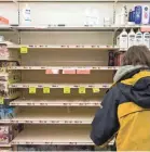  ?? ASHLEY GREEN T&G STAFF ?? A woman takes a look at empty shelves formerly filled with liquid hand soap on Friday.