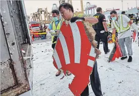  ?? ED WRAY GETTY IMAGES ?? A man carries a piece of the Lion Air flight JT 610 wreckage at the Tanjung Priok port on Friday in Jakarta. Search and rescue personnel have found the flight data recorder.