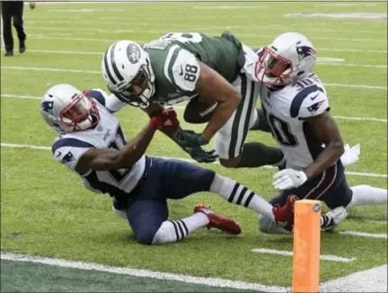  ?? BILL KOSTROUN — ASSOCIATED PRESS ?? Jets tight end Austin Seferian-Jenkins is tackled by Patriots’ Malcolm Butler, left, and Duron Harmon during the second half of Sunday’s game in East Rutherford, N.J. The play was reviewed a fumble into the end zone.