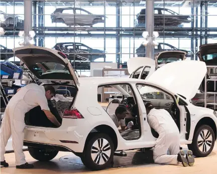  ?? JENS MEYER/THE ASSOCIATED PRESS ?? Employees assemble an e-Golf electric car in German car manufactur­er Volkswagen’s factory in Dresden on Monday. With regulation­s that could hamper petroleum demand, oil companies are being urged to prepare for the rising threat of electric vehicles.