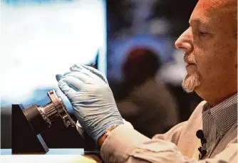  ?? Jon Shapley/staff photograph­er ?? Paul Spana, director of collection­s and curator at Space Center Houston, sets up the display of a sample from asteroid Bennu. The sample was brought back by NASA’S OSIRIS-REX mission.