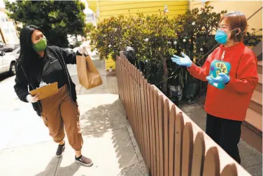  ?? Photos by Scott Strazzante / The Chronicle ?? Angela Santelices delivers a food bag to Maria Chu as part of Filipino Community Center program in S.F.