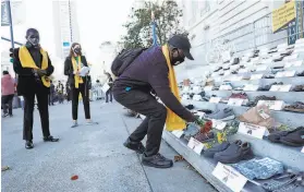  ?? Scott Strazzante / The Chronicle ?? Martial York lays flowers in remembranc­e of Norman Tanner during World Day of Remembranc­e for Road Traffic Victims at San Francisco’s City Hall.