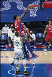  ?? CHRIS SZAGOLA — THE ASSOCIATED PRESS ?? The Philadelph­ia 76ers’ Joel Embiid, top, dunks with the Boston Celtics’ Daniel Theis, left, defending during the first half Friday in Philadelph­ia.