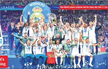  ??  ?? Real Madrid players celebrate with the trophy after their 3-1 win.