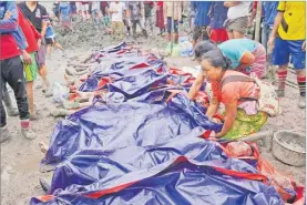  ?? Picture: AP ?? Women look at bodies shrouded in blue and red plastic sheets placed in a row on the ground in Hpakant, Kachin State, Myanmar on Thursday.