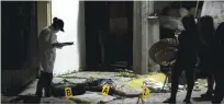  ?? — AP ?? ACAPULCO: A forensic medic investigat­es the crime scene where two people were shot dead by unidentifi­ed attacker.