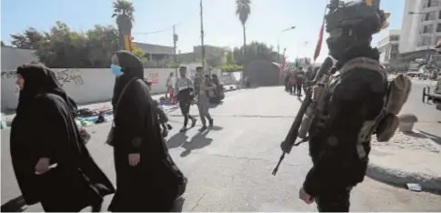  ?? ABC ?? Un policía iraquí junto a un grupo de peregrinos chiíes ayer en el centro de Bagdad