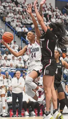  ?? Tyler Sizemore/Hearst Connecticu­t Media ?? UConn guard Aubrey Griffin, left, makes a layup over South Carolina forward Kamilla Cardoso on Sunday.