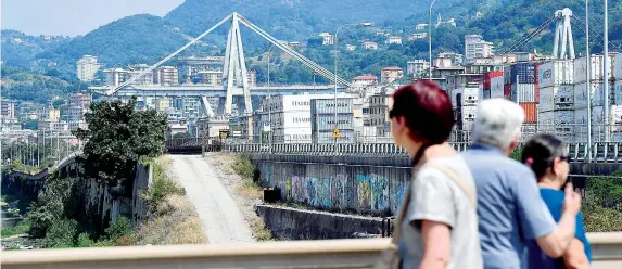  ??  ?? I resti Alcuni cittadini osservano ciò che rimane del ponte Morandi. La struttura è collassata il 14 agosto scorso uccidendo 43 persone (Luca Zennaro/ansa)